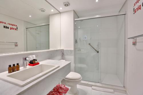 a bathroom with a shower and a sink and a toilet at Radisson RED Campinas in Campinas