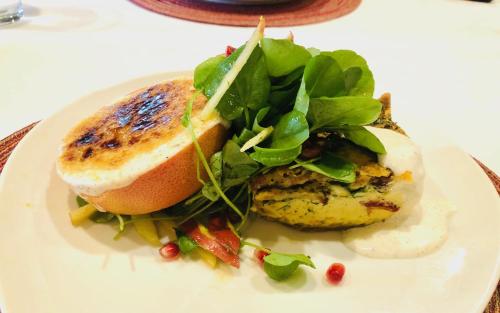 a white plate with a sandwich and greens on it at Casa Sedona Inn in Sedona