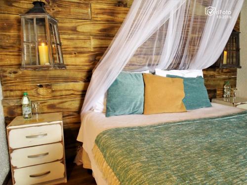 a bedroom with a bed with a canopy and a night stand at La Perla del Cabo in Cabo Polonio