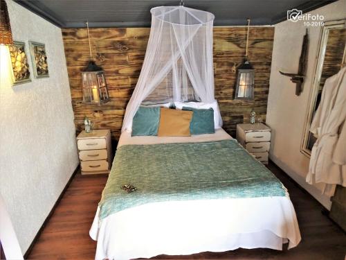 a bedroom with a bed with a canopy at La Perla del Cabo in Cabo Polonio
