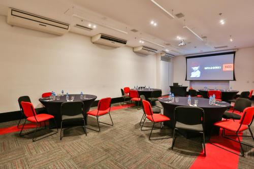a conference room with tables and chairs and a screen at Radisson RED Campinas in Campinas