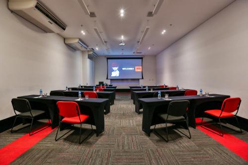 a conference room with tables and chairs and a screen at Radisson RED Campinas in Campinas