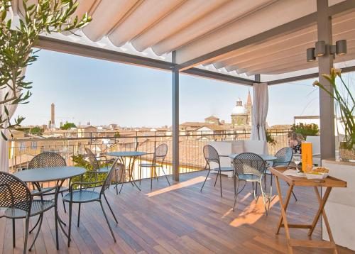 a patio with tables and chairs and a view of the city at Hotel Touring in Bologna