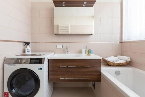 uma casa de banho com uma máquina de lavar roupa e um lavatório em Großes Penthouse #12 mit Terrasse und Aussicht em Viena