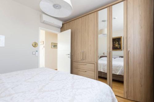 sypialnia z białym łóżkiem i drewnianą szafką w obiekcie Großes Penthouse #12 mit Terrasse und Aussicht w Wiedniu