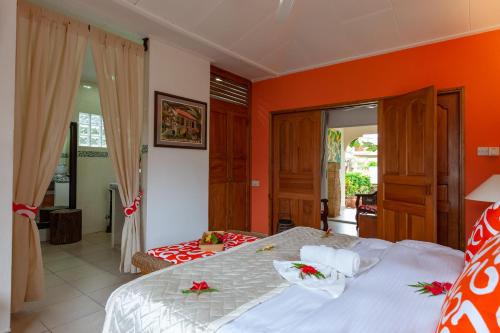 a bedroom with a bed and an orange wall at Oceane L'union Villa in La Digue
