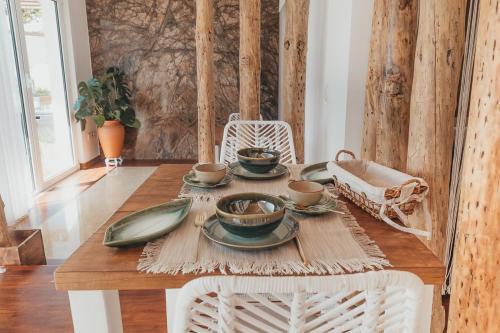 a table with plates and cups on top of it at Joy Beach House in São Pedro de Moel