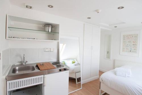 a bedroom with a white bed and a white counter top at 272&294 Franciscan Road Rooms&Studios by EveryWhere to Sleep London in London