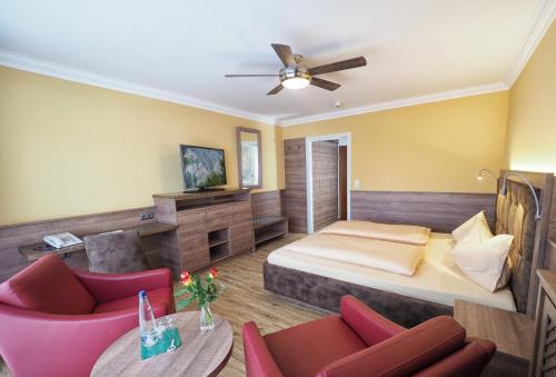 ein Schlafzimmer mit einem Bett und ein Wohnzimmer in der Unterkunft Hotel Olympia in Bad Füssing