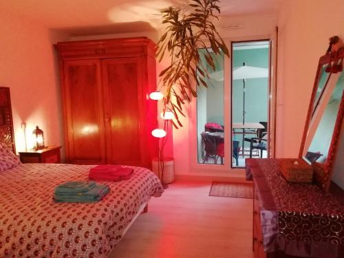 1 dormitorio con cama, mesa y espejo en LE KATZALA, en Mulhouse