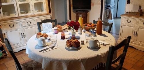une table avec un tissu de table blanc et de la nourriture dans l'établissement La Maison Josnes de Mady, à Josnes