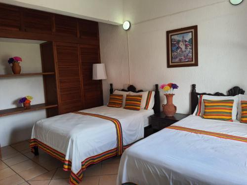 a hotel room with two beds in a room at Hotel Casa Zoque Colonial in Tuxtla Gutiérrez