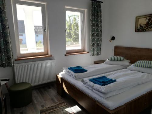 a bedroom with two beds with blue towels on them at Casa Ago - Guest House in Păuliş