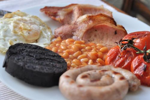 a plate of breakfast food with eggs bacon beans and tomatoes at Bank House B and B in Penrith