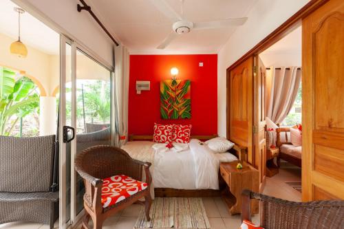 a bedroom with a bed and a red wall at Oceane L'union Villa in La Digue