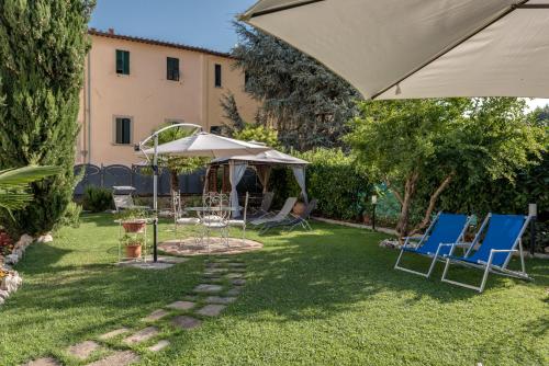 a group of chairs and an umbrella in a yard at Residence Le Gagli arde in Arezzo