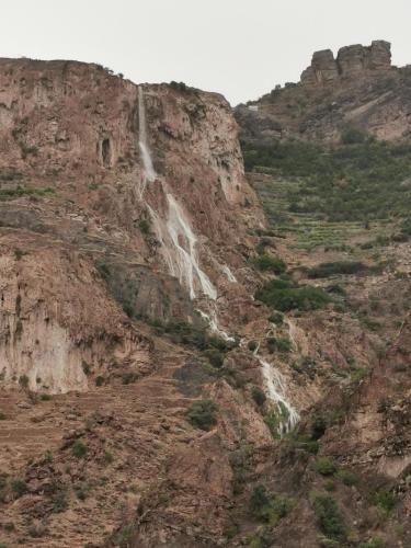 a waterfall on the side of a rocky mountain at Salassel Al Jabal Al Akhdar Guesthouse in Al ‘Aqar