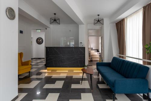 a living room with a blue couch and a television at Hotel PASO in Cluj-Napoca