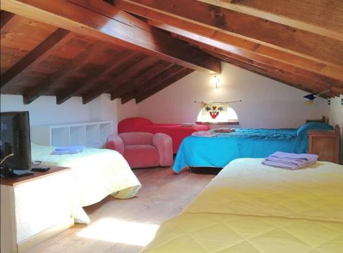 Pokój z 2 łóżkami, telewizorem i kanapą w obiekcie La casetta di Biancaneve Valtellina e lago di Como w mieście Dubino