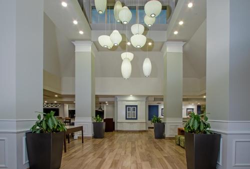 a lobby with white columns and potted plants at Shutters Hotel in Elko