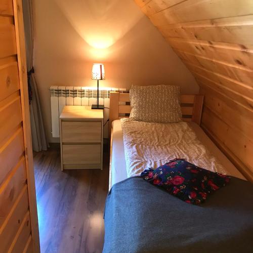 a small bedroom with a bed and a night stand at Babie Domki in Zawoja