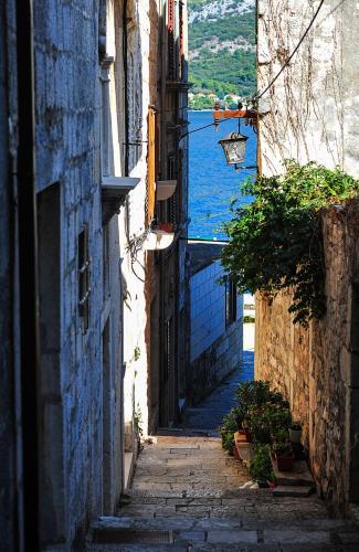 an alley with a view of a body of water at House Vilović Korčula in Korčula