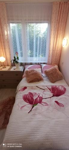 ein Schlafzimmer mit einem Bett mit rosa Blumen drauf in der Unterkunft Magdalenka in Legnica