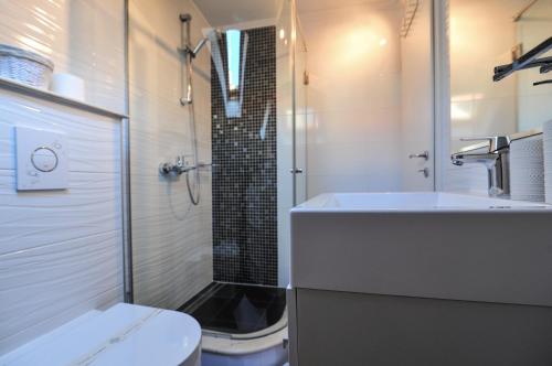 a bathroom with a sink and a shower and a toilet at House Vilović Korčula in Korčula
