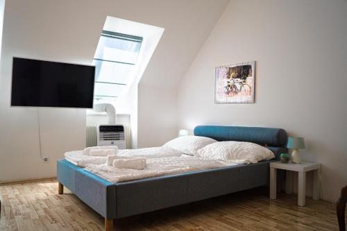 1 dormitorio con 1 cama y TV en la pared en Ideal 2BR - Lovely for Longstays, en Viena