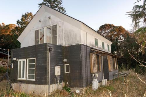 une maison assise dans l'herbe dans l'établissement Minamiizu Land Hopia - Vacation STAY 83984, à Ihama