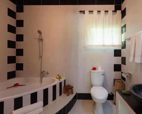 a bathroom with a tub and a toilet and a sink at Oceane L'union Villa in La Digue