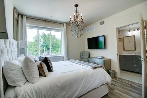 a bedroom with a large white bed with a chandelier at The Bishop Arts Hotel By Bluelofts in Dallas