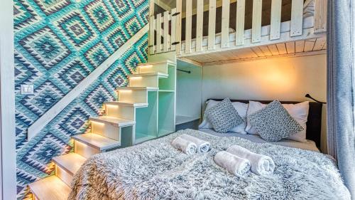 1 dormitorio con 1 cama al lado de una escalera en Apartament Garden z Sauną Holiday Mountain Residence - 5D Apartamenty, en Świeradów-Zdrój