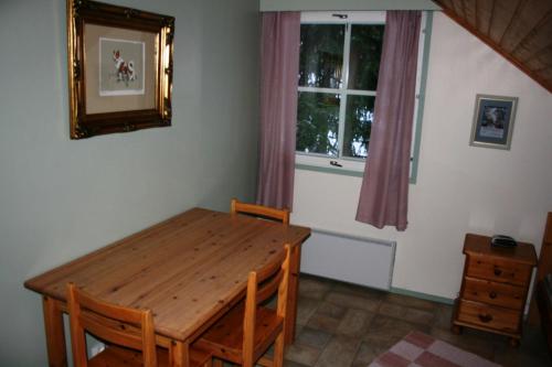 a dining room with a wooden table and a window at Lohijärven Eräkeskus in Lohijärvi