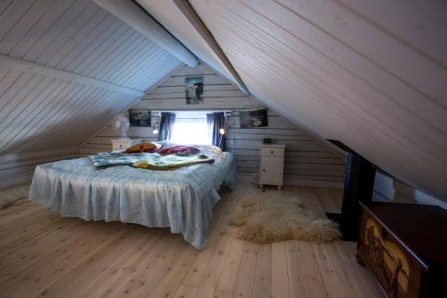 a bedroom with a bed in a attic at Hugsnäset Semesterstugor och Fiske in Gällö