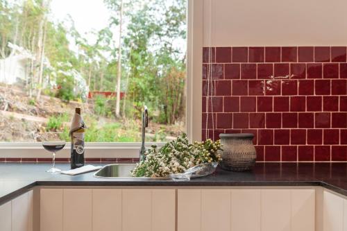 a kitchen counter with a sink and a window at Cabanas da Viscondessa in Urzelina