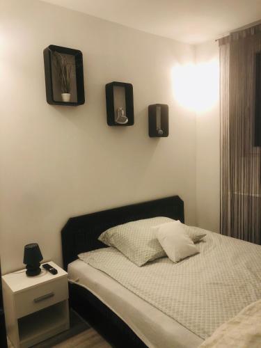 a bedroom with a bed with two lights on the wall at Belvárosi Apartman 1 in Miskolc