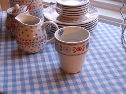 a table with three cups and plates on a table at Skålleruds Gård in Åsensbruk