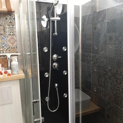 eine Dusche mit einer Glastür in einem Badezimmer in der Unterkunft Beau studio refait a neuf centre ville avec clim balcon in Narbonne