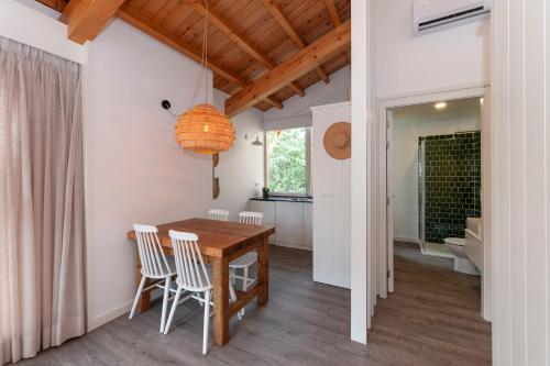 a kitchen and dining room with a wooden table and chairs at Cabanas da Viscondessa in Urzelina