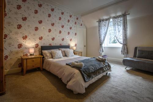 a bedroom with a bed and a couch and a window at Charming Townhouse on North Coast 500 Route, Wick in Wick