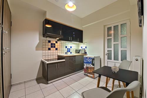 a kitchen with black cabinets and a table and chairs at Alexia's Apartments in Rio