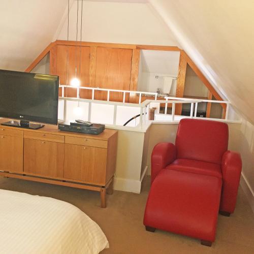 a bedroom with a red chair and a television at Morris House Hotel in Philadelphia