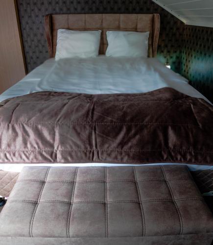 a large bed with a brown blanket on it at HOTELLMILANO AS in Mosjøen