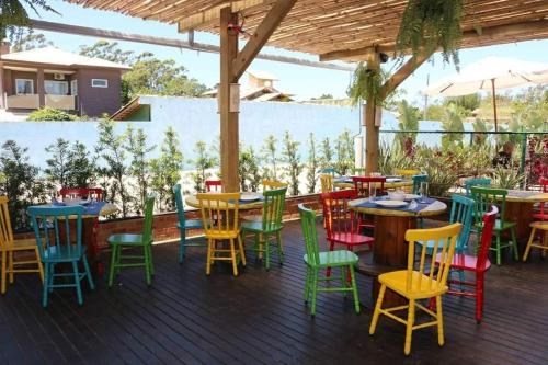una terraza con mesas y sillas coloridas. en Pousada Moçamba Dunas Beach, en Florianópolis