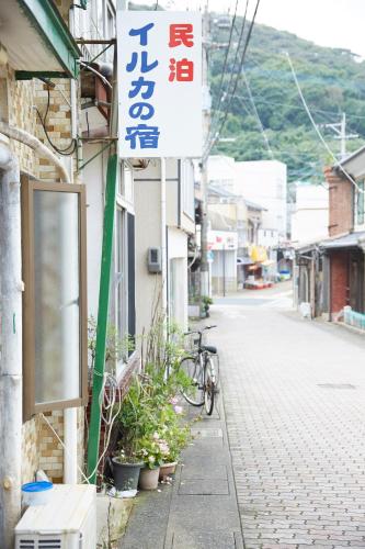 uma placa na lateral de um edifício com uma bicicleta estacionada no exterior em Iruka House 1 - Vacation STAY 9266 em Iki