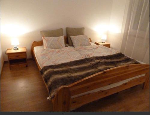 - une chambre avec un lit en bois et 2 tables de chevet dans l'établissement Eldorado 44, à Loèche-les-Bains