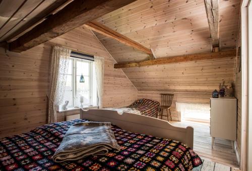 a bedroom with a bed in a wooden room at Hugsnäset Semesterstugor och Fiske in Gällö