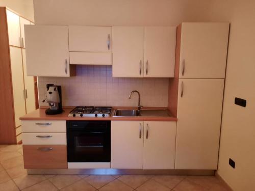 a kitchen with white cabinets and a sink and a stove at Monolocale in Via Poerio in Catanzaro