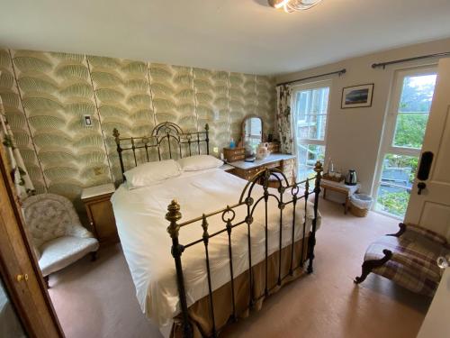 a bedroom with a bed and a chair and a window at The Stables, Ulverston in Ulverston